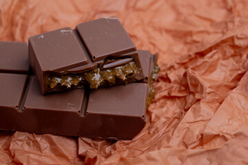 Bar of dark, milk chocolate with filling, Dubai chocolate. Delicious chocolate close-up with nut filling