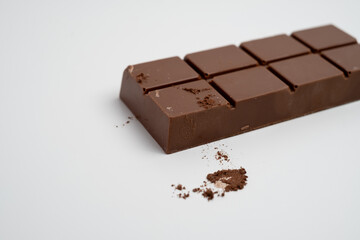 Spoon with cocoa powder and delicious chocolate with filling on table, top view. Milk, dark chocolate bar