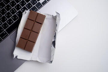 Top view of dark chocolate bar wrapped in foil. Delicious chocolate close-up with nut filling

