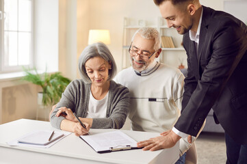 Senior couple signing paper, young professional consultant helping advising on right legal...