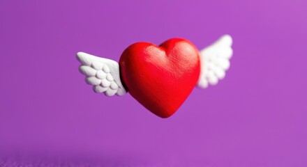 Fototapeta premium Red heart with white wings floating against a purple background