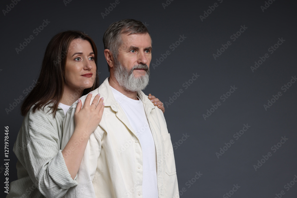 Wall mural Daughter and her father on dark background, space for text