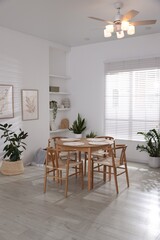 Stylish wooden table with chairs and decor indoors. Interior design