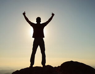 Fototapeta premium silhouette of a man on a mountain top, silhouette of a man with arms outstretched, a person celebrating his success on the top of a mountain 