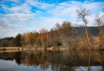 small pond of Dietrichstein in the Southern Austrian province of Carinthia on a cold autumn day with water reflection