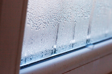 Condensation, mold, high humidity in the house. Foggy windows, humidity problem. high humidity in the house. hand wipes off water condensation from plastic window glass in the room 