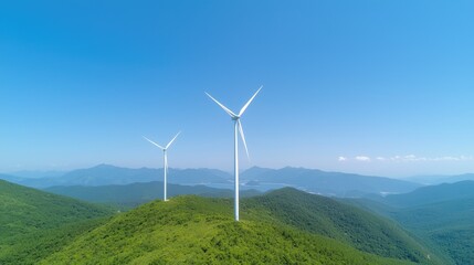 Wind turbines atop green hills, clear sky, distant mountains.  Renewable energy