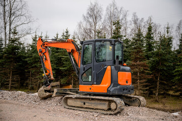 orange excavator with a hydraulic arm and bucket at construction site	