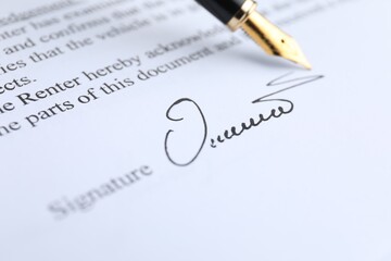 Obraz premium Fountain pen leaving signature on contract, closeup