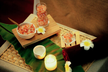 Exfoliation treatment in luxury spa salon with warmth candle light ambient. Salt scrub beauty treatment composition table in Health spa body scrub. Quiescent