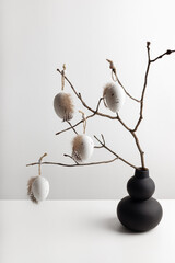 Easter composition with modern vase and decorative eggs hanging on the twigs. Easter natural background.