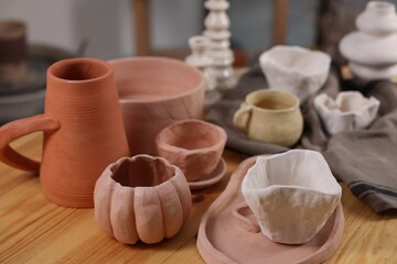 Hobby and craft. Different beautiful pottery on wooden table indoors, closeup