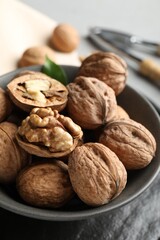 Fresh walnuts in bowl on table, closeup