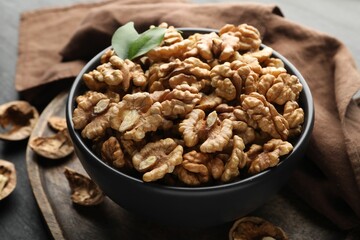Fresh ripe walnuts in bowl on table, closeup