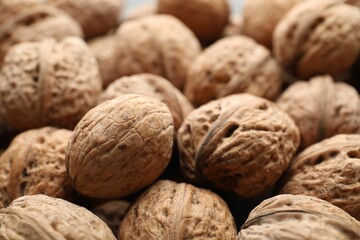 Fresh walnuts in shells as background, closeup
