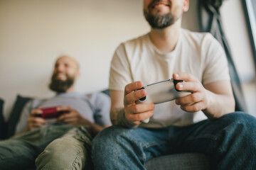 Happy two men enjoying video game in a living room.