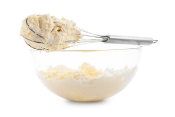Bowl and whisk with delicious cream isolated on white