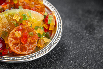 Candied peel and fruit orange, kumquat, tangerine, cherry, mango and others Sugar-coated fruit fresh tasty food dish delicious gourmet food background on the table rustic food top view copy space