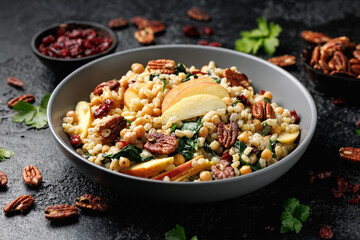 Warm barley pearl salad with kale, dried cranberries, apples and roasted pecan nuts. Healthy food