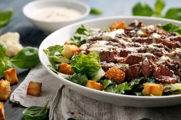Beef steak Caesar salad with croutons, parmesan cheese and lettuce. Healthy food