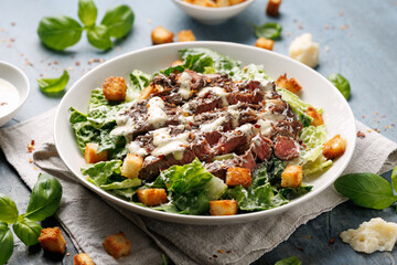 Beef steak Caesar salad with croutons, parmesan cheese and lettuce. Healthy food