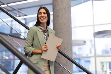 Young Latina businesswoman standing with a thoughtful gaze in an office