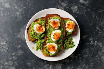 Smashed peas and egg sourdough toast with whole grain mustard sauce. Protein packed vegetarian food concept