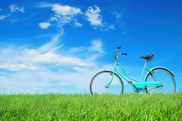 Fototapeta premium Vintage Bicycle in a Green Field Under a Bright Blue Sky
