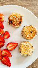 Plate with national ukrainian dish syrnyky and strawberries for breakfast 