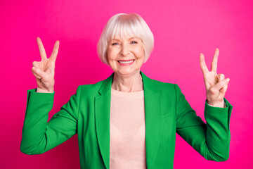 Close-up portrait of her she nice attractive cheerful cheery glad gray-haired lady wearing blue green jacket showing double v-sign isolated on bright vivid shine vibrant pink fuchsia color background
