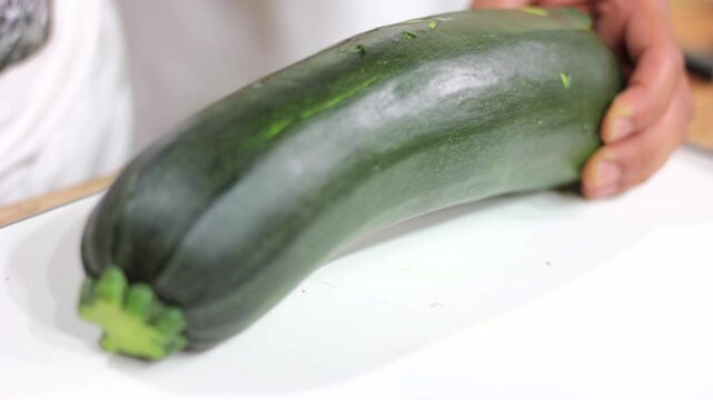 Man chopping juicy zucchini courgette
