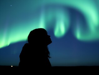 A human female is filled with a deep sense of awe and oneness with the cosmos as they look at the Northern Aurora, their outline merging with the ethereal lights overhead.