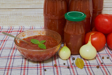 jars of tomato sauce, Jar of tomato sauce, ripe slices of tomato and spoon. Creative food background.