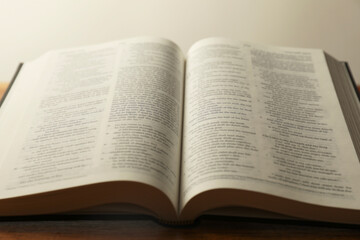 Open Holy Bible in English language on wooden table, closeup
