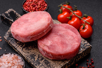 Two fresh slices of raw tuna fillet with spices and herbs