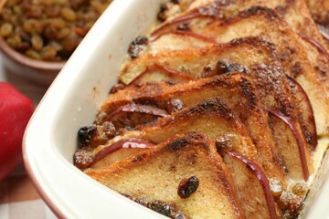 Delicious bread pudding in baking dish on table, closeup