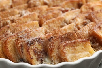 Delicious bread pudding with raisins and cinnamon in dish, closeup