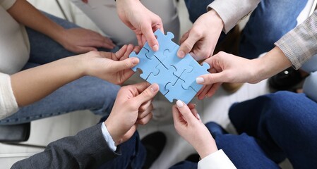Unity concept. People putting puzzle pieces together indoors, top view