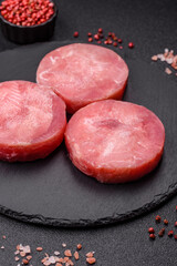 Two fresh slices of raw tuna fillet with spices and herbs