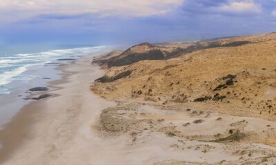 Coastal dunes meet the ocean. Dramatic sand formations meet the waves. Nature's artistry. Opononi, Hokianga Harbour, Northland, NZ
