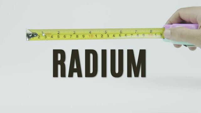 "Radium" text with a yellow tape measure on a white background, symbolizing precision, accuracy, and the measurement of radioactive elements and scientific analysis in a clean, minimal video