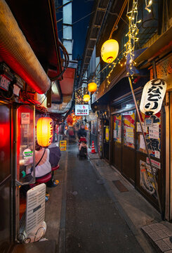 tokyo, shinjuku - jan 13 2025: A bustling night scene in Shinjuku Omoide Yokocho featuring a narrow alleyway illuminated by Japanese lanterns and neon signs, small eateries in a vibrant atmosphere.
