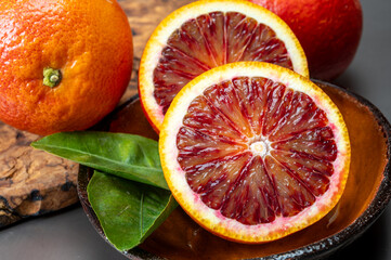 Sicilian sweet juicy yellow and red blood oranges with green leaves close-up