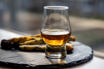 Whiskey and cheese pairing, tasting whisky glass and plate with sliced blue stilton and blue shropshire cheeses, Great Britain food and drink