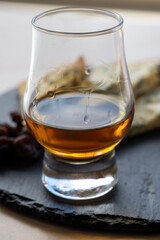 Whiskey and cheese pairing, tasting whisky glass and plate with sliced blue stilton and blue shropshire cheeses, Great Britain food and drink