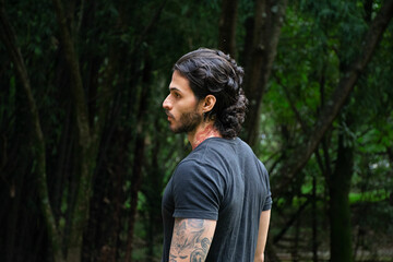 Young tattooed man portrait in a park outdoors
