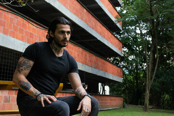 Young man sitting on a bench in a park outdoors