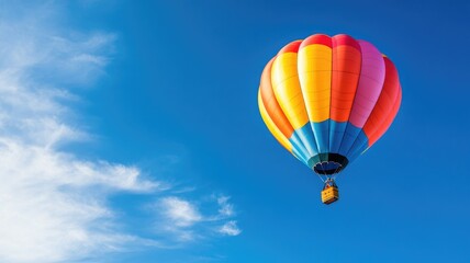 Naklejka premium Vibrant hot air balloon floating in clear blue sky
