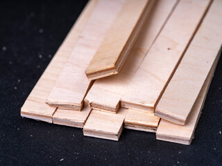 Oblong pieces of plywood on a black background.