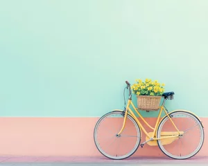 Poster a yellow bicycle leaning against a two-tone wall with a basket of flowers. The scene evokes a sense of simplicity, and the flowers in the basket add a touch of joy to the composition.